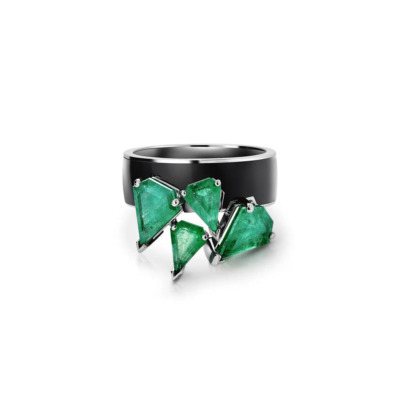 Ring featuring multiple emerald stones set in a black band with a geometric design.