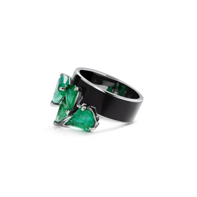 Ring featuring multiple emerald stones set in a black band with silver accents.