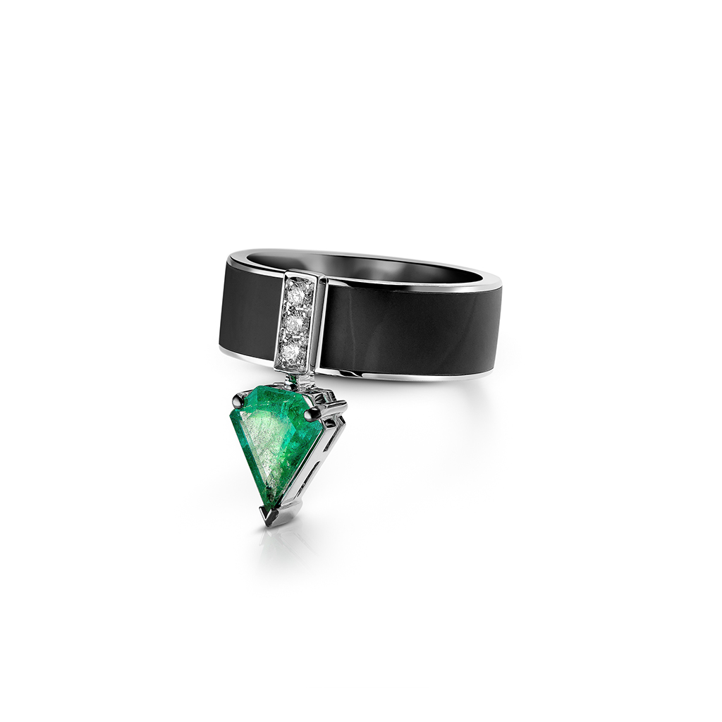 Ring featuring a kite cut emerald set in a black band with diamond accents.
