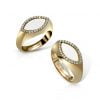 Gold marquise signet ring pair featuring white stones and diamond accents, elegant jewelry for special occasions.
