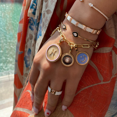A hand adorned with various gold and silver jewelry pieces including bracelets and rings.