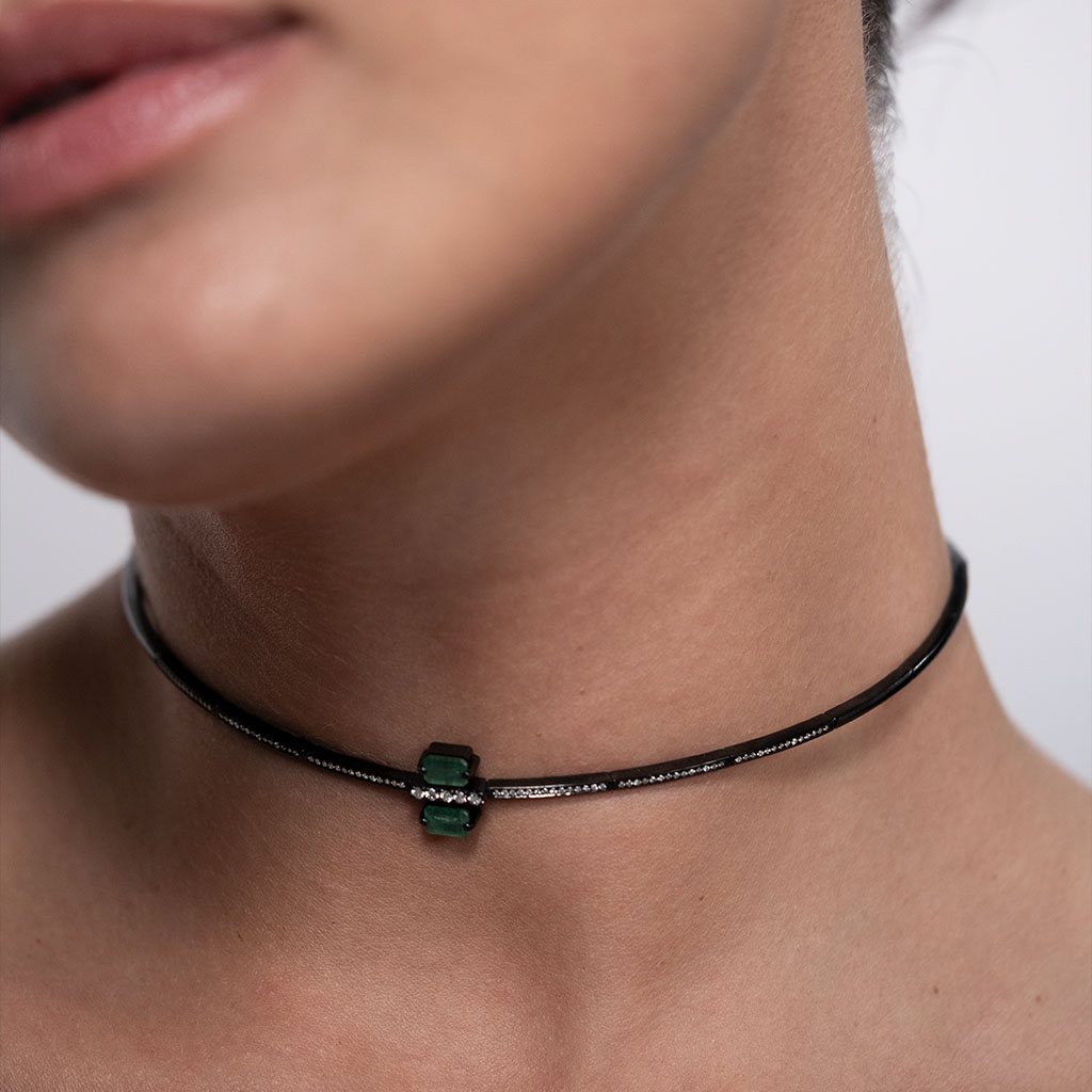 Stylish Linette choker featuring a sleek black band and green gemstone accents, perfect for modern fashion aesthetics.