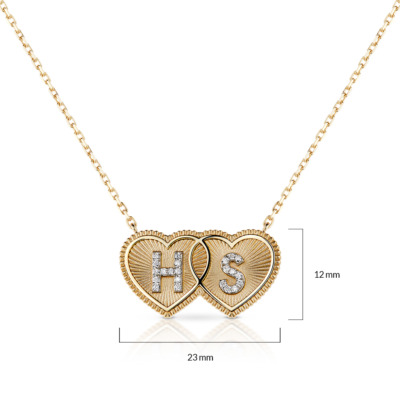 Gold necklace featuring two interlocking heart pendants with initials HS and diamond accents.