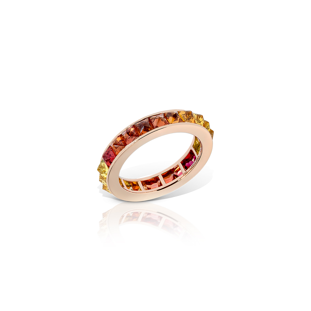Single row eternity band featuring ombre sapphires set in a circular gold band.