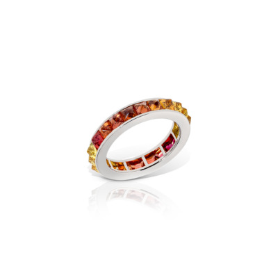 Single row eternity band featuring ombre sapphires in shades of orange and pink set in white gold.