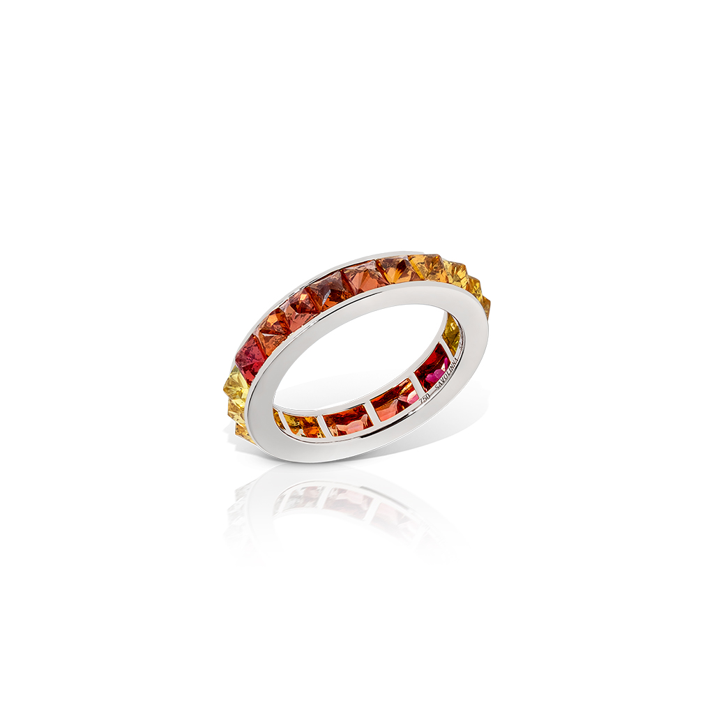 Single row eternity band featuring ombre sapphires in shades of orange and pink set in white gold.