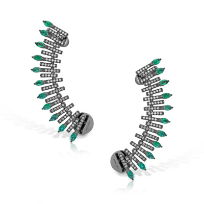 A pair of ear climber earrings featuring emerald and diamond accents arranged in a spiked design.