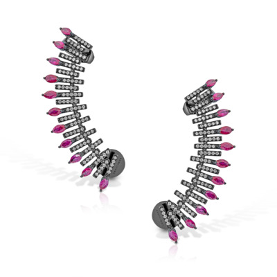 A pair of spiked ear climber earrings featuring ruby and clear gemstones arranged in a curved design.