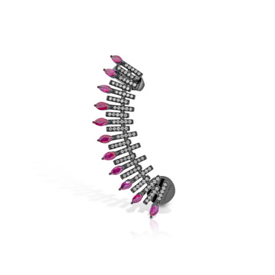 A spiked ear climber featuring ruby-colored stones and clear crystals arranged in a curved design.