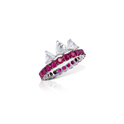 Ring featuring a band of rubies and three triangular diamonds set in white gold.