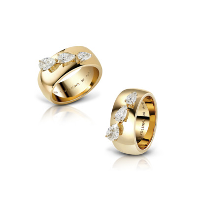 Two gold rings featuring pear-shaped diamonds arranged in a decorative pattern.