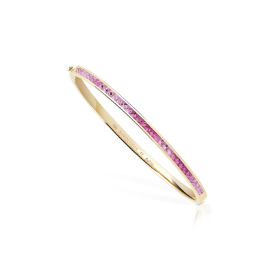 Extra slim bangle featuring a single row of pink sapphires set in yellow gold.