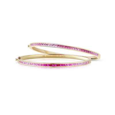 Two extra slim bangles featuring a single row of pink sapphires set in yellow gold.