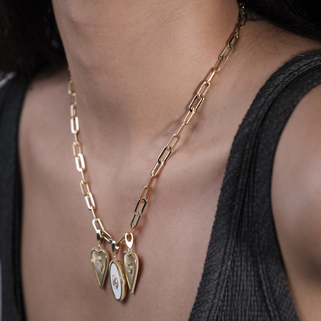 Gold heart charm necklace featuring three locket pendants, designed for elegance and style, perfect for personal expression.