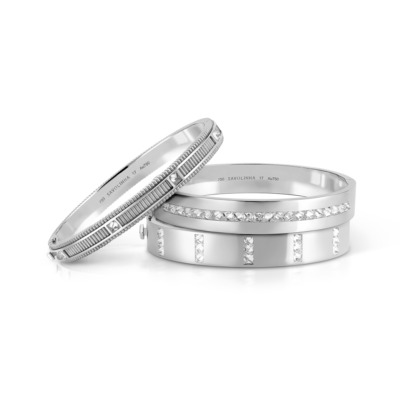 Two silver bangles featuring decorative patterns and embellishments.