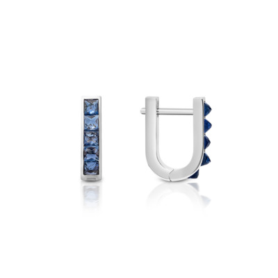 Mini huggie earrings featuring a single row of blue sapphires set in white gold.