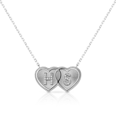 Silver double heart necklace featuring the initials HS in a decorative design.