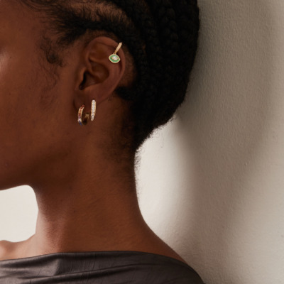 Close-up of a woman's ear showcasing a lemonade enameled 18K yellow gold diamond ear cuff.