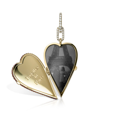 Gold elongated heart-shaped locket with ruby accents and a photo of the Eiffel Tower inside.