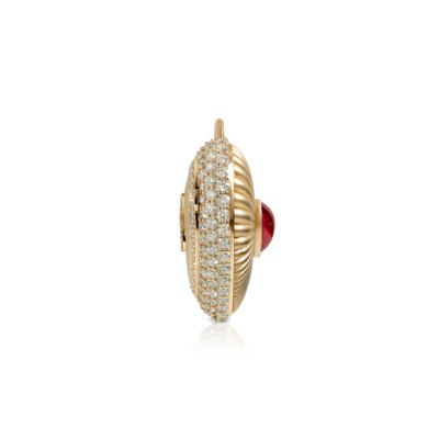 Gold love locket featuring a red stone and diamond embellishments on the surface.