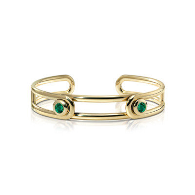 Forme Beam Cuff in polished 18k gold featuring two green emerald accents set at each end, emphasizing the sleek, architectural open cuff design with a luminous, refined sparkle