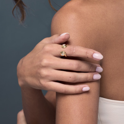 Savolinna Forme Arc Ring Slim Model in 18k gold featuring a small diamond, showcasing the curved open design and polished finish with a delicate bri‐lliance